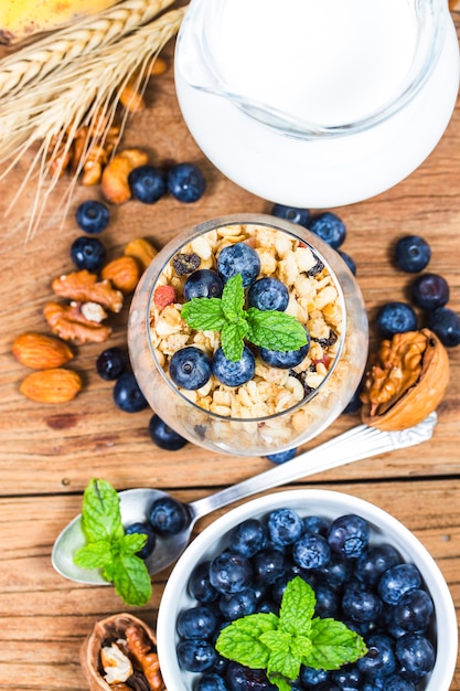 Prima colazione sana: granato di avena con yogurt e mirtilli freschi su fondo in legno