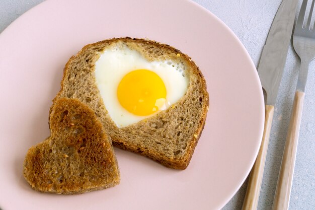 Prima colazione. Uova e toast a forma di cuore.