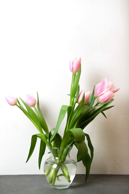 Primavera accogliente composizione di tulipani rosa in vaso sul tavolo