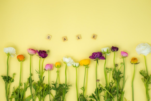 primavera flatlay concetto di fondo con fiori e vendita parola di legno