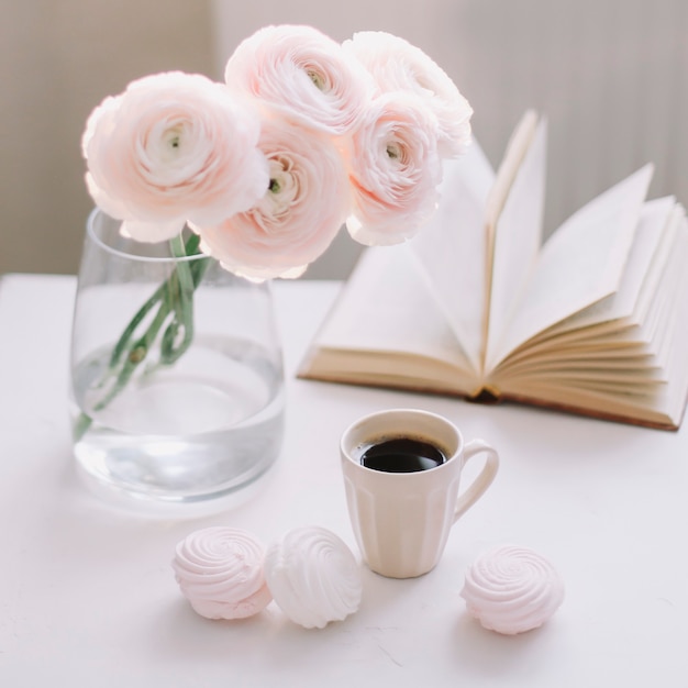 Primavera romantica natura morta con fiori, tazza di caffè, un libro e marshmallow