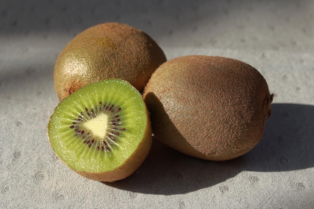 Primi piani di kiwi, uno dei quali è tagliato a metà