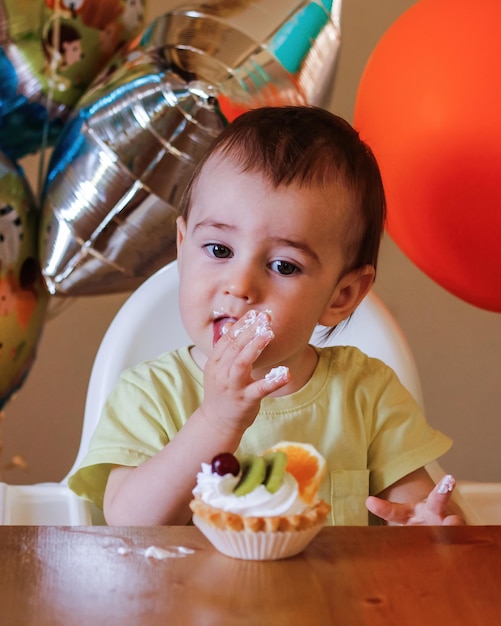 Primo compleanno Bambino carino che festeggia il suo primo compleanno con una torta a casa