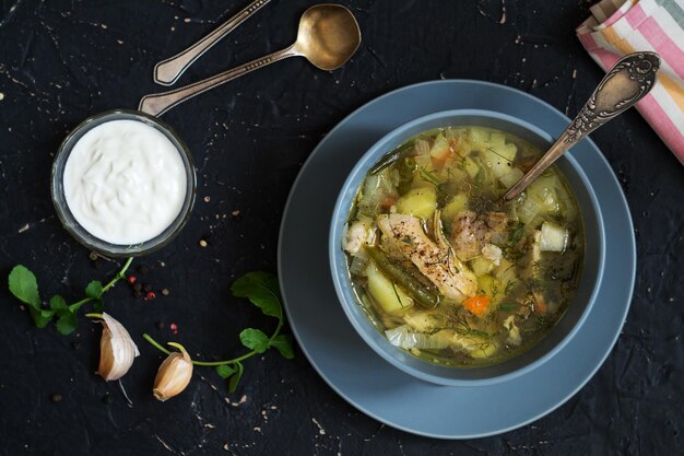 Primo corso. Zuppa di pollo e salsa di panna acida su un tavolo scuro