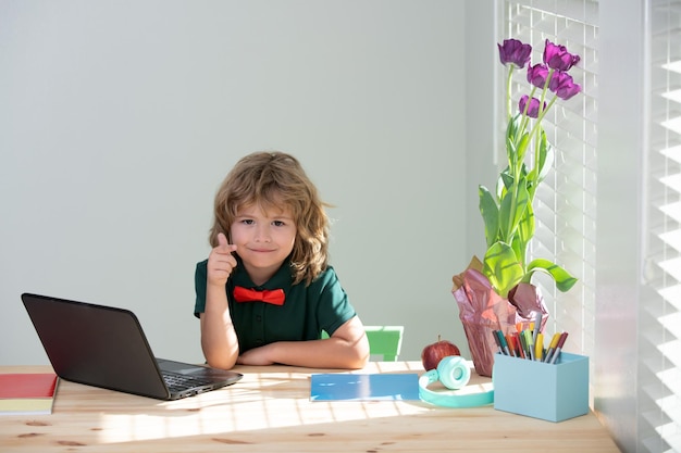 Primo giorno a scuola bambini carini che usano un computer portatile che studiano attraverso l'elearning sch