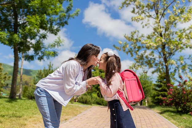 Primo giorno di scuola, la madre guida una bambina in prima elementare