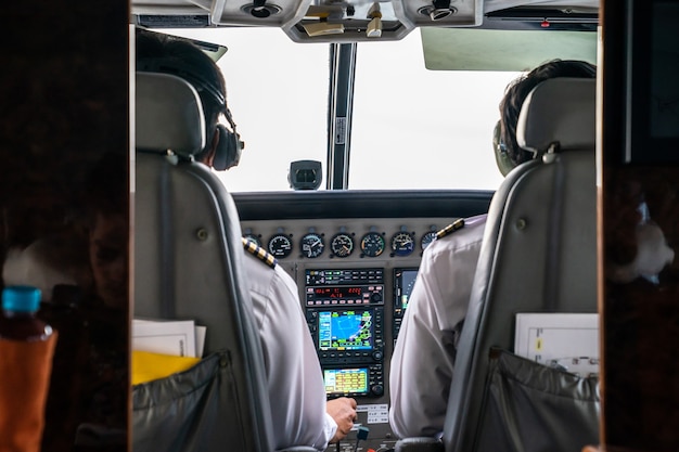 Primo piano 2 piloti concentrati guidano il piccolo jet privato nel cielo.