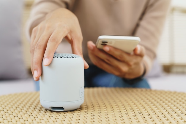 Primo piano a portata di mano utilizzando il telefono che collega l'altoparlante bluetooth