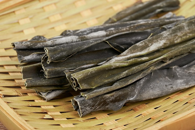 primo piano alga secca Laminaria (Kelp) sul piatto di legno Sfondo. kombu