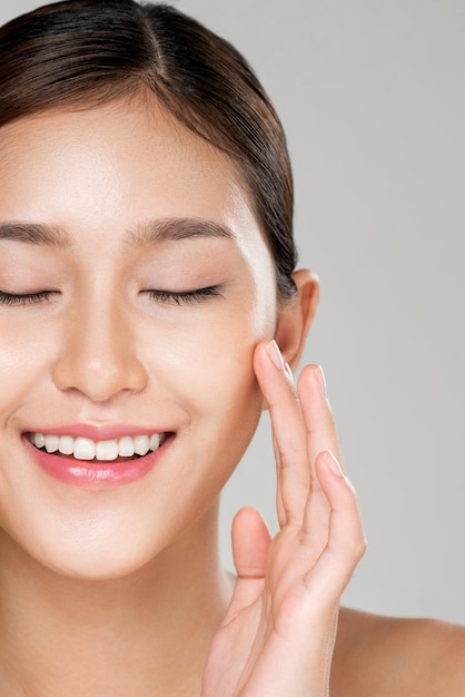 Primo piano ardente giovane donna in posa gesto di bellezza con pelle fresca pulita