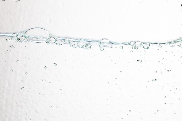 Primo piano bolle sott'acqua su sfondo bianco.