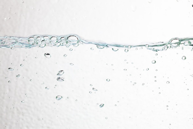 Primo piano bolle sott'acqua su sfondo bianco.