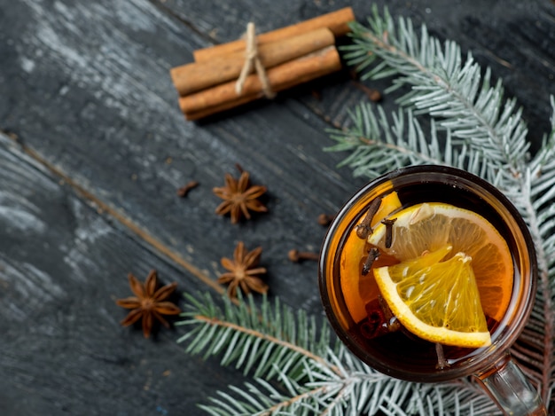 Primo piano caldo del vino sciupato bevanda calda di inverno sulla tavola con i rami di albero