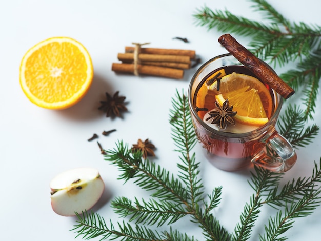 Primo piano caldo del vino sciupato bevanda calda di inverno sulla tavola con i rami di albero