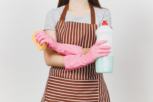 Primo piano casalinga ritagliata in guanti rosa, grembiule a righe isolato su sfondo bianco. Donna che si tiene per mano incrociata, bottiglia con liquido detergente per lavare i piatti, spugna. Copia spazio per la pubblicità.