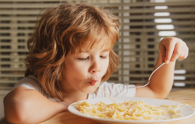 Primo piano colpo di testa di bambino che mangia spaghetti di pasta I bambini affrontano il ritratto del ragazzino