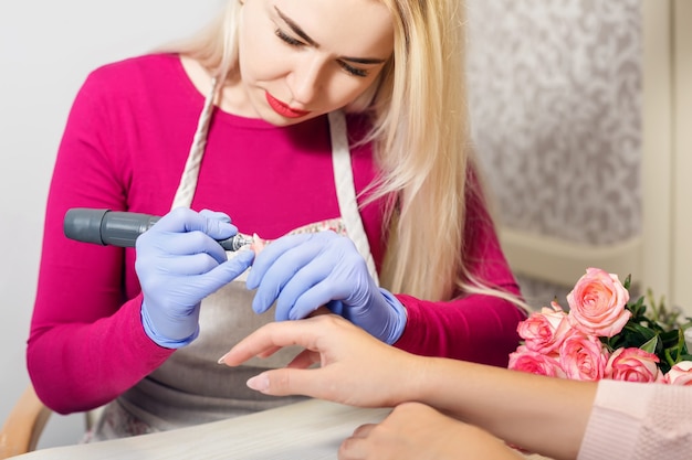 Primo piano cura delle unghie del dito da specialista di manicure nel salone di bellezza