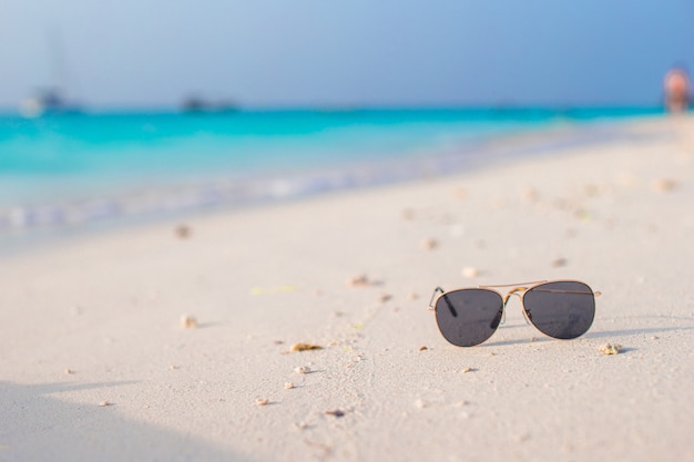 Primo piano degli occhiali da sole sulla spiaggia tropicale