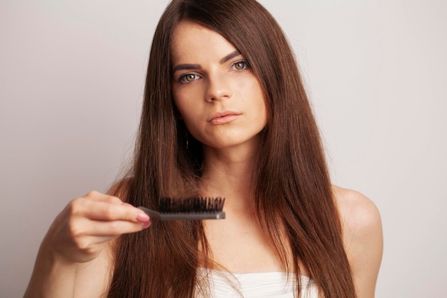 Primo Piano Dei Capelli Di Spazzolatura Dei Capelli Della Bella Donna Con La Spazzola.