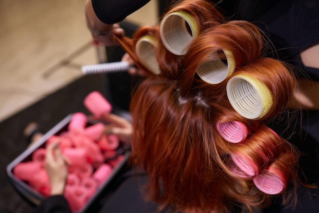 Primo piano dei capelli rossi durante la preparazione dei capelli con il bigodino