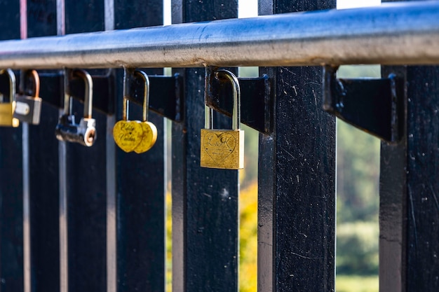 Primo piano dei lucchetti dell'amore appesi a un recinto del ponte