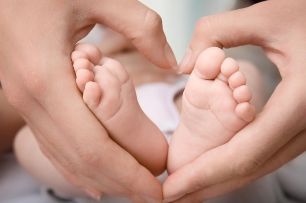 Primo piano dei piedi del bambino della tenuta della madre