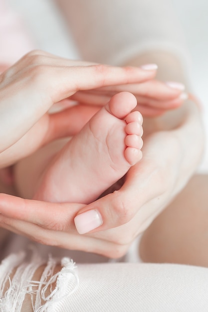 Primo piano dei piedi del bambino nelle mani della madre