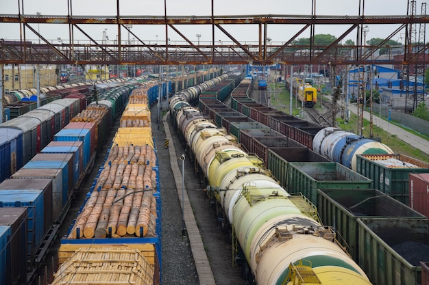 Primo piano dei treni merci. Vista aerea dei treni sulla stazione ferroviaria. Carri con legno e olio. Autunno