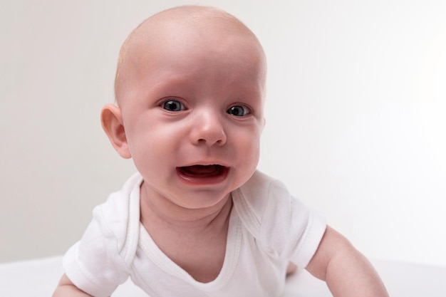 Primo piano del bambino su uno sfondo bianco che piange