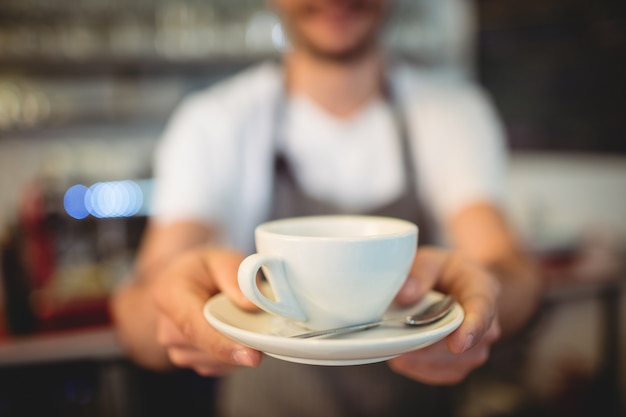 Primo piano del barista che serve caffè alla caffetteria