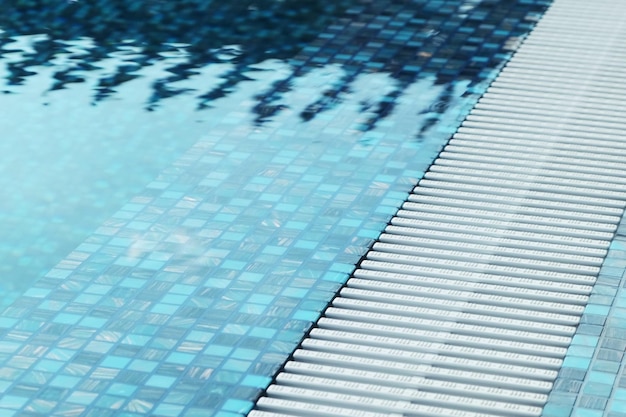 Primo piano del bordo della piscina in tessere di mosaico blu Acqua cristallina in piscina Rilassatevi nel cortile di una casa di campagna