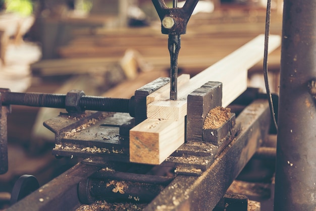 Primo piano del carpentiere che taglia una plancia di legno