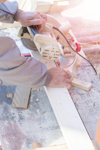 Primo piano del carpentiere che taglia una tavola di legno