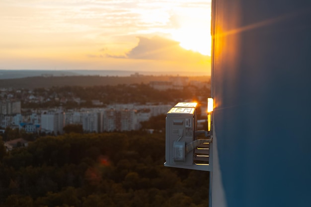 Primo piano del compressore esterno del condizionatore d'aria fissato sulla facciata sullo sfondo del bellissimo tramonto