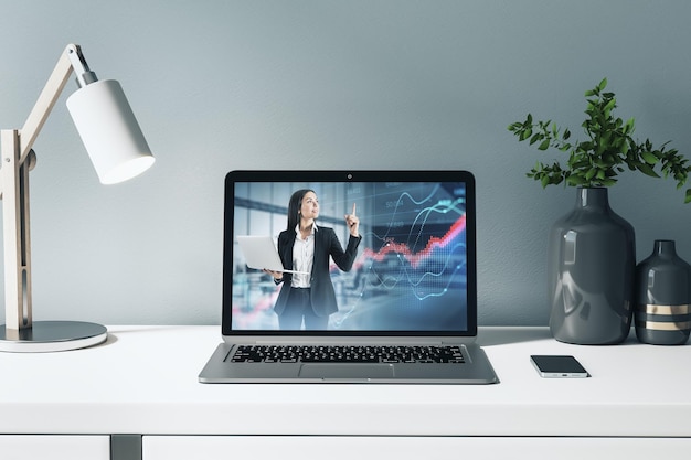 Primo piano del computer con una donna d'affari che dà educazione finanziaria sullo schermo con un grafico aziendale posizionato sul desktop sullo sfondo interno del posto di lavoro dell'ufficio luminoso Conoscenza e concetto di webinar