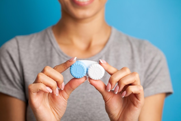 Primo piano del contenitore della holding della donna con le lenti a contatto