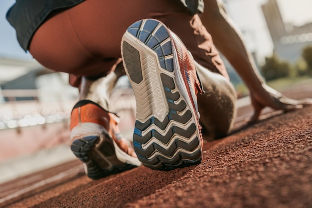 Primo piano del corridore in posizione di partenza Focus su scarpe da ginnastica