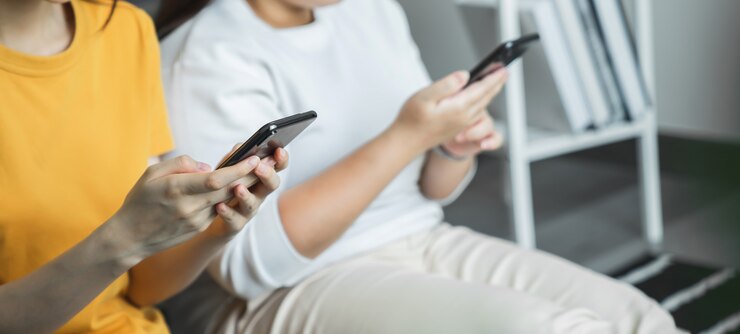 Primo piano del dispositivo dello smartphone della tenuta della mano e messaggio di testo di battitura a macchina sul sociale online.