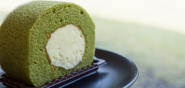 Primo piano del dolce del rotolo svizzero del tè verde di Matcha sul piatto