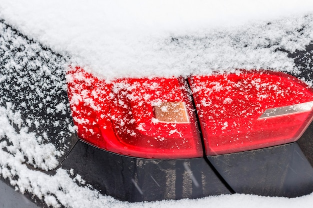 Primo piano del faro dell'automobile. Auto con la neve in inverno