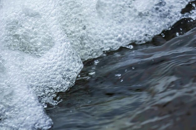 Primo piano del flusso d'acqua, piccola cascata, spruzzi d'acqua, bolle d'acqua, acqua che scorre