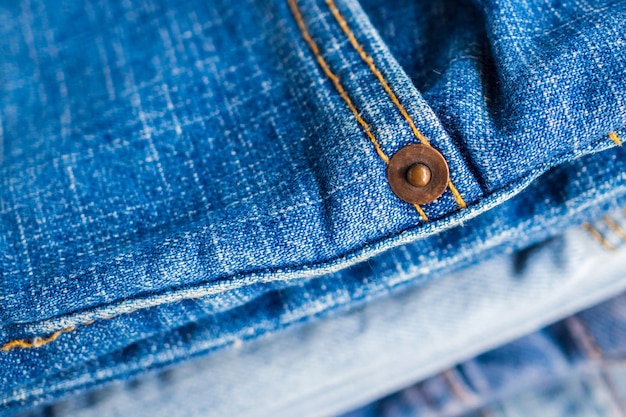 Primo piano del fondo di struttura della pila delle blue jeans del denim