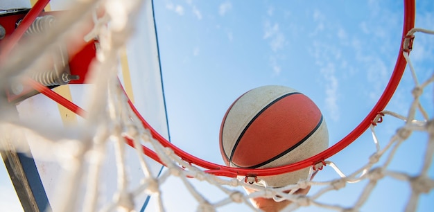 Primo piano del giocatore di basket lancia la palla nel canestro da basket