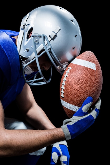 Primo piano del giocatore di football americano turbato con la palla