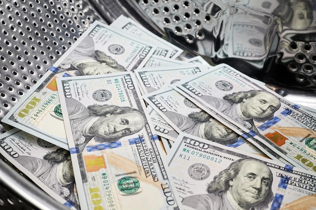 Primo piano del lavaggio di dollari nel concetto di frode finanziaria di riciclaggio di denaro della macchina