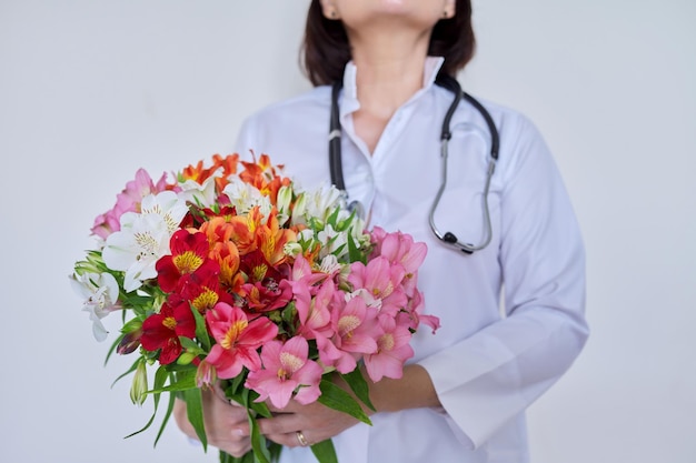 Primo piano del mazzo di fiori nelle mani del medico femminile