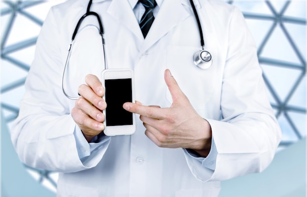 Primo piano del medico maschio che punta allo smartphone