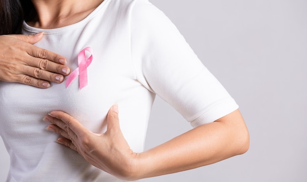Primo piano del nastro distintivo rosa sul petto della donna per sostenere la causa del cancro al seno