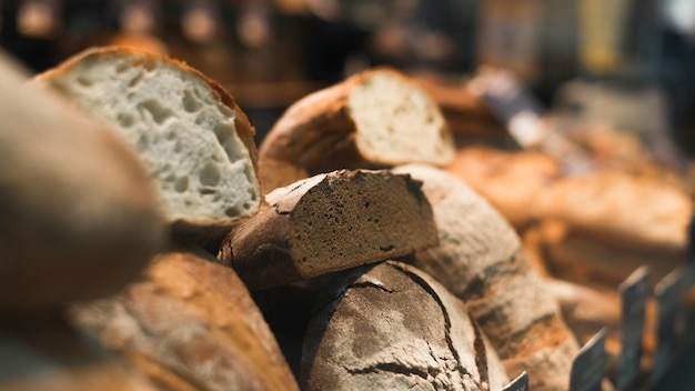 Primo piano del pane bianco fresco e di segale al forno sulla messa a fuoco morbida selettiva della finestra del negozio