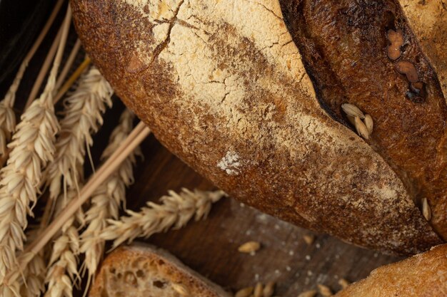 Primo piano del pane fatto in casa Pane contadino e spighetta di grano con spazio per il testo Cottura fatta in casa Pane intero grigio su tavola di legno